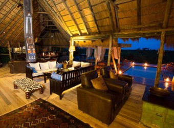 Selinda Camp, amazing outdoor dining circle set around a campfire, luxury dining, high end safari, African safari luxury, Botswana candlelit dinner