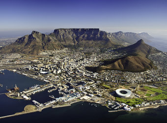 Overhead view of Cape Town and Table Mountain rising towards the heavens behind the buildings, picturesque places in South Africa