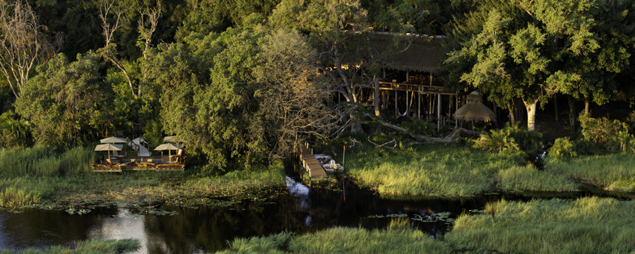 Elegantly situated safari camp on the lush western side of the Okavango Delta, dock next to the Delta with boat for wildlife viewing, lounge area 