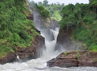 Murchison Falls thunder through the rocky valley creating vicious white water complimented by bright green grasses